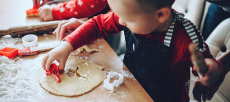 Upper view photo of a small boy making cookies using forms during the xmas preparationの写真素材