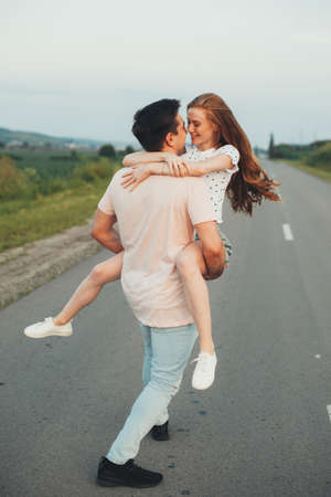 Caucasian ginger woman is embracing her lover smiling at each other on the roadの写真素材