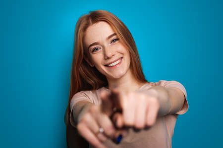 Woman with freckles point at camera for lifestyle design photo. Fashion model. Hand gesture