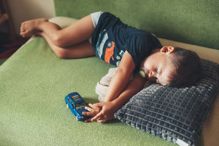 Kid sleep with car toy. Summer napping for children. Relaxational conceptの写真素材