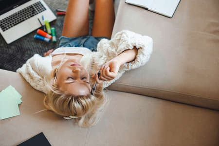 Woman using laptop and feeling tired on floor. Online education. Homeschooling during lockdown.の写真素材