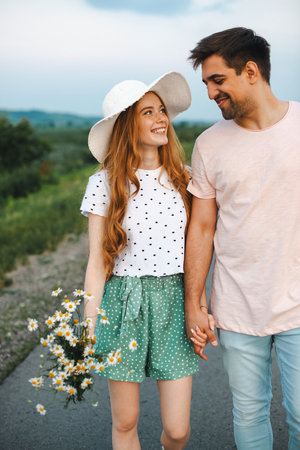 Beautiful closeup photo of couple on road holding flower. Springtime concept. Spring flowers. Love concept. Happy loving family. Summer concept. Road trip.の写真素材