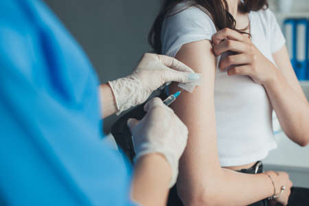 Close up of doctors hands give injection to a patient in hospital. vaccination. virus immunization....