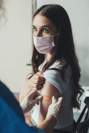 Doctor putting plaster adhesive bandage on a patient arm after injection vaccine. Adult immunization, covid vaccine. Healthcare, coronavirus. Healthy lifestyle.の写真素材