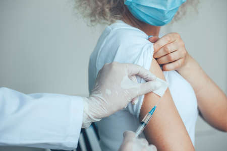 Close-up portrait of doctor's holding syringe and using cotton before make injection to patient. Professional medical concept. Covid vaccination concept. Injection covid vaccine concept. Quarantine lifestyle.の写真素材