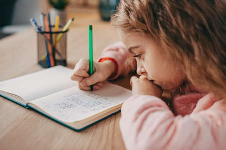 Little girl making her homework. Independent Girl. Education.の写真素材