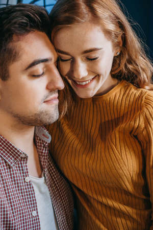 Close up portrait of a loving young couple embracing each other with closed eyes. Smiling face. Front view. Familyの写真素材