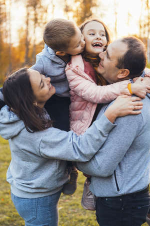 Happy family of four posing in the park. Closeup portrait. Spending time together.の写真素材