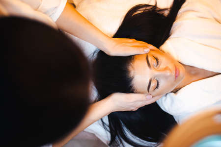 Caucasian woman having a facial massage in a spa salon. Closeup portrait of a beauticians hands. Facial treatment. Health care. Beauty skin care. Beauty face.の写真素材