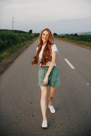 Caucasian woman posing while walking having fun on a road outside the city. Freedom journey. Beauty face.の写真素材