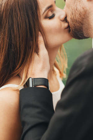 Wedding portrait of lovers kissing outdoors. Close-up beautiful portrait of newlyweds kissing.