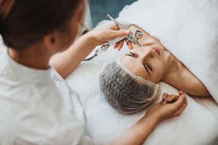 Beautician using equipment for microcurrent lift face for rejuvenation. Rejuvenation treatment. Dermatology, cosmetology. Cosmetology beauty procedure.の写真素材