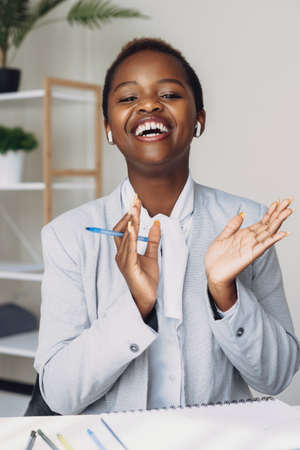Portrait of afro businesswoman explaining something smiling and looking at camera in the office....