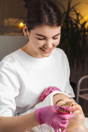 Close-up portrait of woman getting facial hydro microdermabrasion peeling treatment. Beauty...