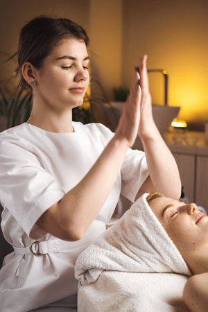 The masseuse rubbed her hands together and prepared to massage the clients face. Cosmetology concept. Beauty treatment. Beauty face. Healthy lifestyle concept.の写真素材