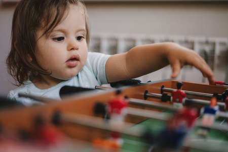 Baby girl with her brother playing table football for relax on holiday in home. Summer relax.の写真素材