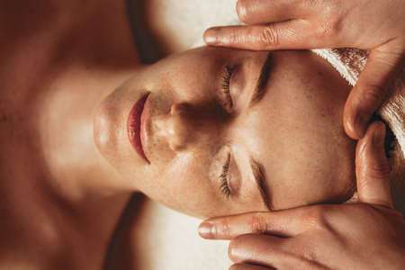Young attractive woman enjoying massage in spa salon. Beauty treatment. Natural skin care cosmetic. Natural woman beauty, skincareの写真素材