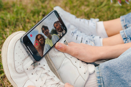 Close-up view of the shoes of some children on whose feet rests a phone that is filming. Online blog video recording living. Morning during quarantineの写真素材
