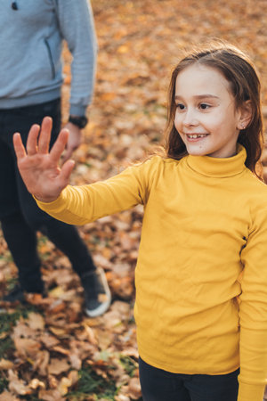 The girl admiring the autumnal nature of the city park. Parent, child. Happy family, childhood. Fun family. Outdoor lifestyle.の写真素材