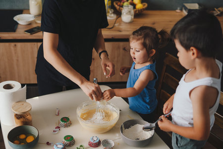 Happy family in the kitchen preparing the dough, baking cookies. Family with kid spending time on home kitchen in morning.の写真素材