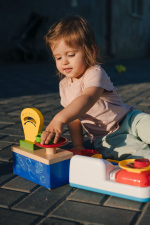 Child playing in the backyard with great toys for developing multiple sensory skills. Concept of happy childhood, discovery and learning.の写真素材