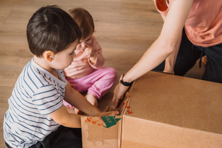 Family gathered around a big box excited to see their new Christmas tree. Happy family, childhood. People lifestyle.の写真素材