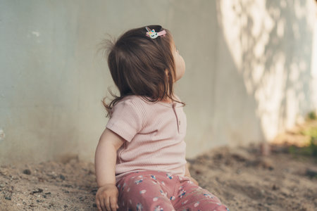 Cute Caucasian baby children sitting in sandbox playing, having fun playground. Summer vacation. Nature summer. Summer outdoor fun activity.の写真素材
