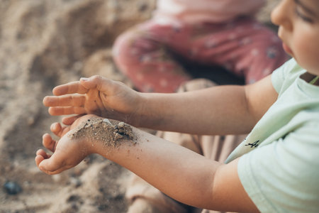 Close-up view of boys hands with sand from the garden. Summer vacation concept. Summer vacation fun. Outdoor fun.の写真素材