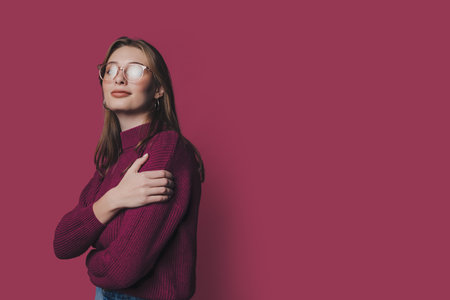 Side view portrait of attractive cheerful businesswoman posing near copy space isolated over crimson color backgroundの写真素材