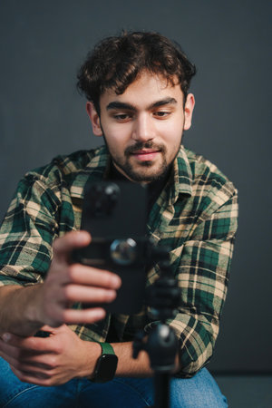 Man live streaming, recording video on smartphone islated over black background.の写真素材