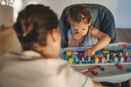 Babysitter playing educational game together with baby girl. Learning by playing education home school concept.の写真素材