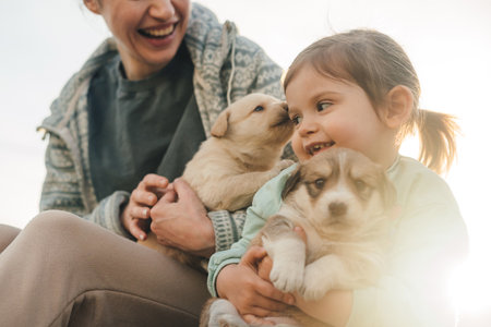 Baby caucasian caressing puppies having fun at home garden. Best friend for kid, family with pet conceptの写真素材