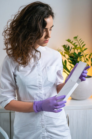 Esthetician looing at a white box in her cabinet .の写真素材
