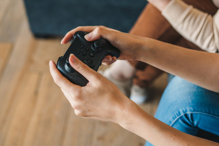 Crop gamer with gamepad playing video game