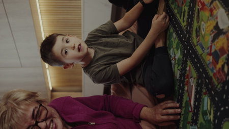 Happy grandmother with kid sitting smiling together in family home in retirement. Senior grandma, smile or children siblings relaxing or bonding to enjoy quality time with old woman.の写真素材