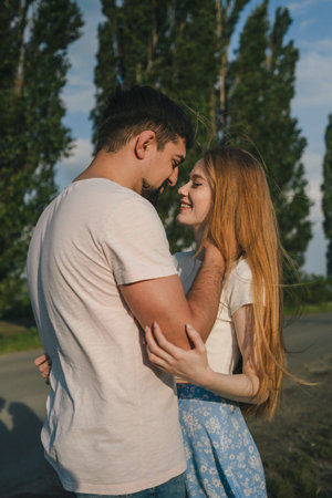 Cropped portrait of couple hugging and laughing cheerfully against the nature background. Togetherness concept.の写真素材