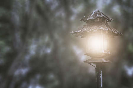 Old isolated lantern lighting at night with dark wood bokeh backgroundの写真素材