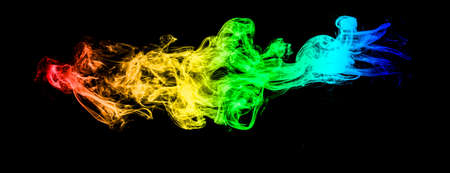 Abstract colorful background. Moving smoke isolated on black background.の写真素材