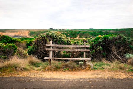 vintage wooden bench stand beside the country road in the sunset sceneの写真素材