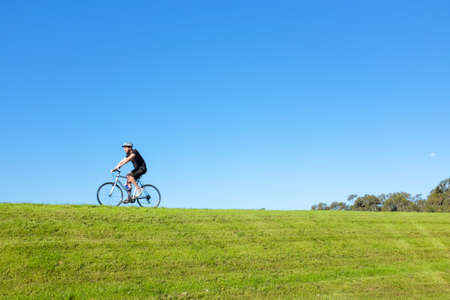 MELBOURNE, AUSTRALIA - OCTOBER 13,2016 : A man cycling at botanic garden at sunsetのeditorial素材