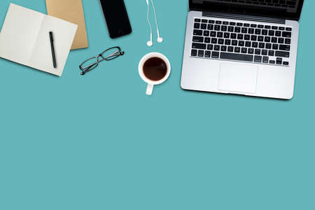 Top view, Working desk, computer, laptop, smart phone, coffee mug, glasses and notebooks on pastel color background with copyspace for text.の写真素材