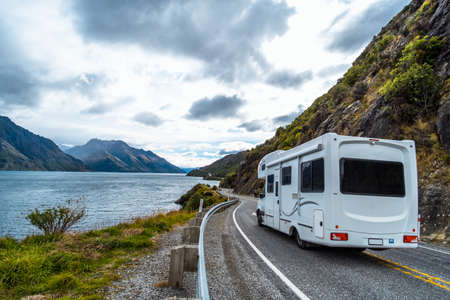 The stunning landscape of road beside the ocean with a cloudy and mountain scene.の写真素材