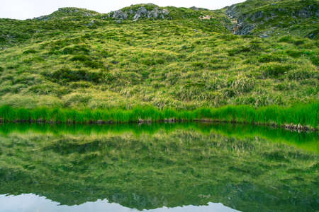The reflection of the rocky mountain with snow on the small lake on the high mountain in Mt Cook National Park (Muller hut track)の写真素材