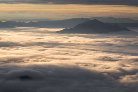 Beautiful sunrise scene at high mountain with yellow clouds and blue sky, Phu chi fah Chiangrai Thailandの写真素材