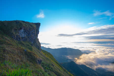 Beautiful sunrise scene at high mountain with yellow clouds and blue sky, Phu chi fah Chiangrai Thailandの写真素材