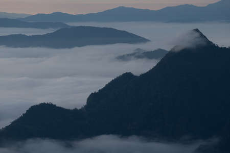 Beautiful sunrise scene at high mountain with yellow clouds and blue sky, Phu chi fah Chiangrai Thailandの写真素材