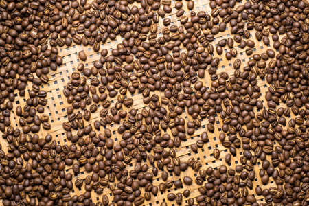 Flay lay style, Medium dark Roasted peaberry coffee beans on bamboo handcraft background.