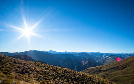 Beautiful landscape of a yellow grassland blue sky and Alps mountain at sunset.の写真素材