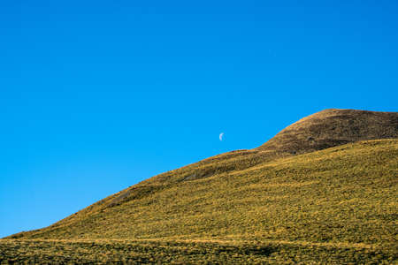 Beautiful landscape of a yellow grassland with blue sky on the high mountain at susnet