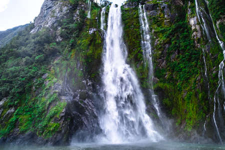 A stunning scene of nature with many waterfalls from the high mountain at Milford Sound, New Zealand.の写真素材